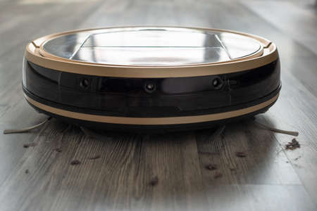 robotic vacuum cleaner on laminate wood floorの写真素材