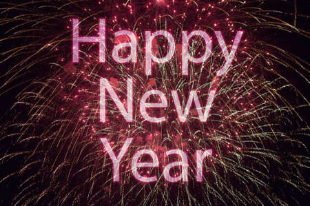 Happy New Year with colorful sparklers. The words Happy New Year are integrated into the fireworks on black backgroundの写真素材