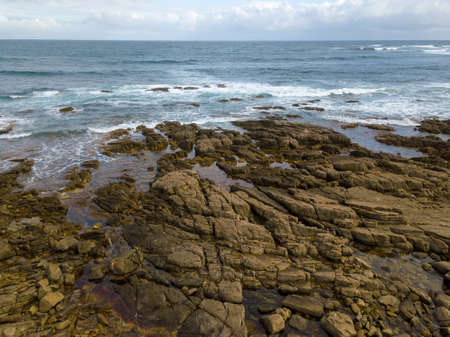 Aerial view of ocean waves and rocky coast