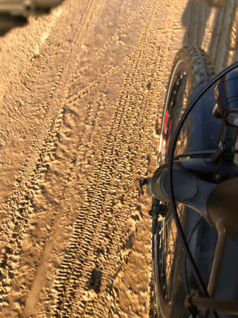 Mountain bike cyclist riding on a wet and muddy road