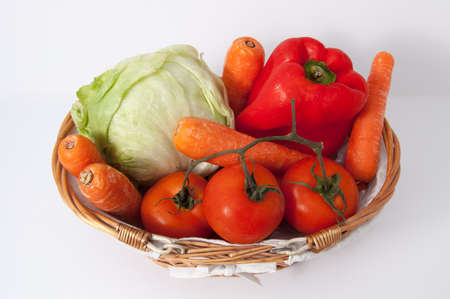 A lettuce, a pepper, some carrots and tomatoes in a basket  White background の写真素材