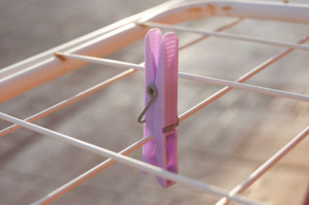 A close shot of a clothes-pin hanging on a clotheslineの写真素材