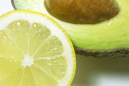 Close up shot of avocado (with stone) and lemon slice. の写真素材