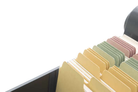 Closeup of an opened box of index cards, isolated on a white background, with copy space above and left.  Black box, white cards with dividers coloured pink, green and yellow.の写真素材