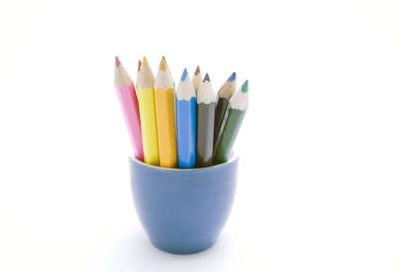 Set of coloured pencils in a blue ceramic container against a white background.  の写真素材