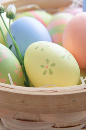 Close up of decorated Easter eggs (hand painted by the photographer) in a woven wooden basket with...