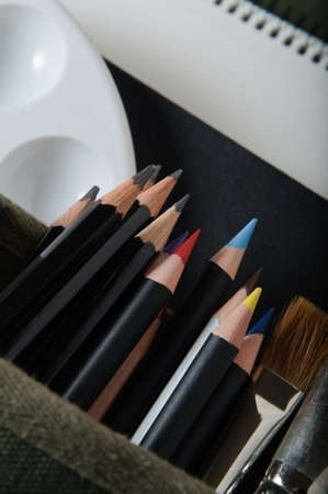 A selection of art materials for drawing and painting, poking out of a cotton canvas artist's satchel.の写真素材