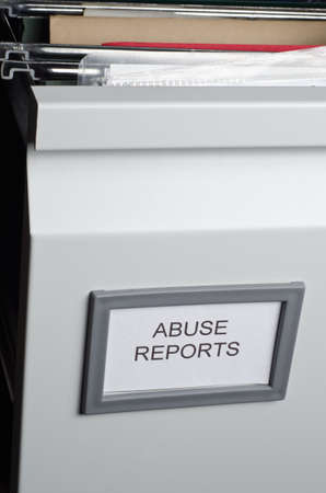 An open filing drawer containing hanging files and documents, labeled 'Abuse Reports'.  Portrait orientation.の写真素材