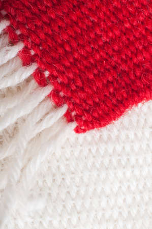 Two weaving samples from a beginners loom.  A plain red piece with light cream fringing rests diagonally above a light cream sample.の写真素材