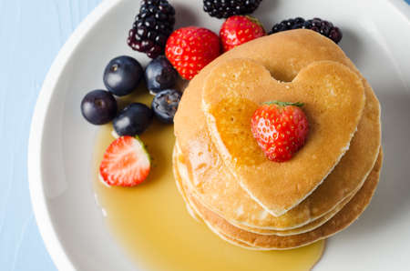 Overhead shot of a stack of pancakes on a white plate