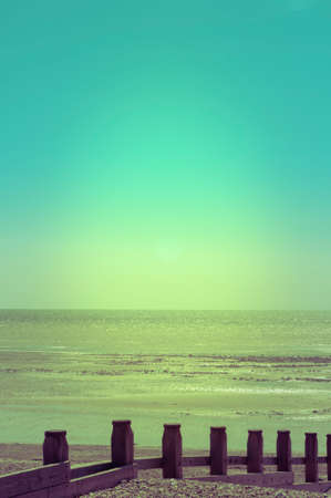 Vertical photograph of a pebble beach shoreline with sea and sky shot in Spring light.の写真素材