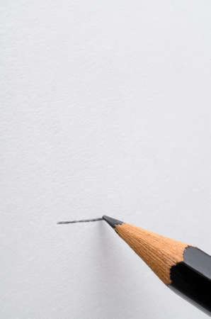 A graphite pencil drawing a line across a blank white page.  Copy space above.の写真素材