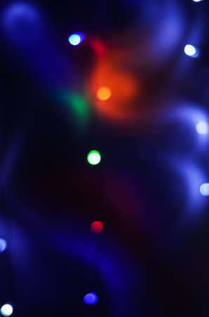 Abstract blurred background from bokeh fairy light effects in various hues of blue, red, green,...