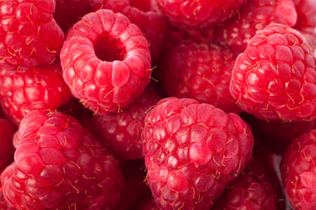 Close up (macro) of multiple red raspberries. Food or fruit background.