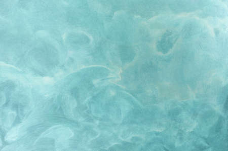 Abstract background texture of swirling aqua blue and white paint with watery wave like movement.の写真素材