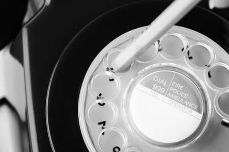 Close up of retro 1960s to 1970s telephone with  number diallling in progress.  Black and white.