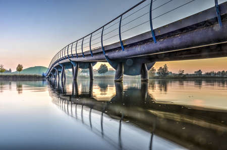Carnisselande, The Netherlands, November 1, 2015: Pedestrian bridge across the lake leading to the artificial mountainのeditorial素材