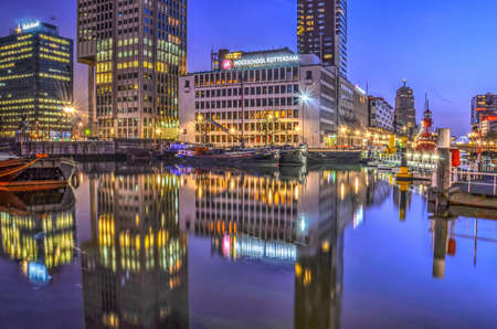 Rotterdam, The Netherlands, December 28, 2016: School, office and residential buildings reflect in the mirror-like surface of Leuvehaven harbour in the morning blue hourのeditorial素材