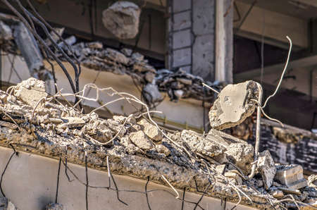 Close up of a building in the process of being demolished, with reinforcement bars sticking out of broken concrte floorsの写真素材