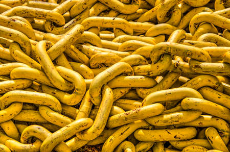 Pile of yellow steel chains in a harbourの写真素材