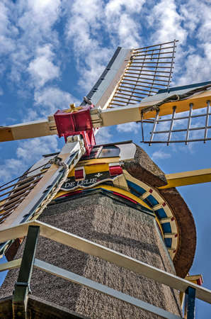 Rotterdam, The Netherlands, September 9, 2018: windmill De Lelie seen from below against a blue summer sky with scattered fluffy cloudsのeditorial素材