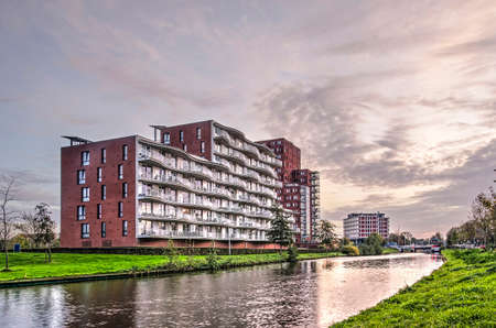 Leeuwarden, The Netherlands, November 3, 2018: modern residential buildings along Dokkumer Ee canal under a spectacular sky at sunsetのeditorial素材