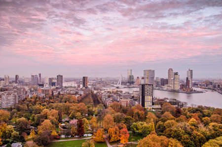 Rotterdam, The Netherlands, November 12, 2018: a view of The Park in autumn colors and neighbourhoods on both sides of the Nieuwe Maas river under a dramatic purple sunset skyのeditorial素材