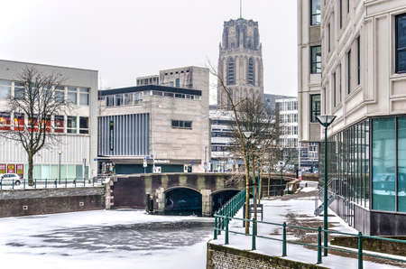 Rotterdam, March 3, 2018: view across frozen and snow-covered Steigersgracht canal between residential and retail buildings towards the tower of Saint Lawrence churchのeditorial素材