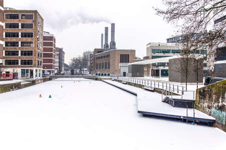 Rotterdam, March 3, 2018: Frozen and snow-covered Steigersgracht on a cold and grey winter day with the smoking chimneys of the city energy plantのeditorial素材