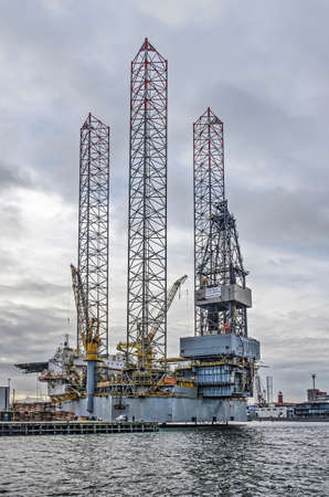IJmuiden, The Netherlands, December 22, 2018: drilling platform with three tall trusses moored at the harbourのeditorial素材