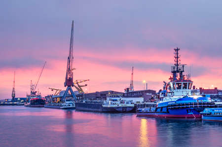 Rotterdam, The Netherlands, December 27, 2018: a blue and purple sky after sunset over a quay with...