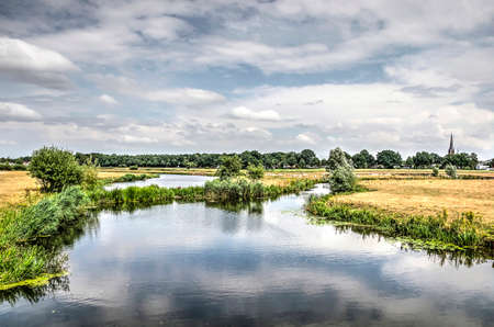 View of the river Mark meandering through a landscape with meadows and woodland near Breda, the...