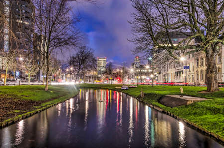 Rotterdam, The Netherlands, January 14, 2019: buildings and traffic on Eendrachtsplein square reflect in the water of Westersingel canal in the blue hour before sunriseのeditorial素材