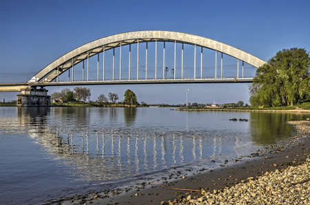 Culemborg, The Netherlands, April 8, 2017: the steel arch of the railway bridge relfecting in the...