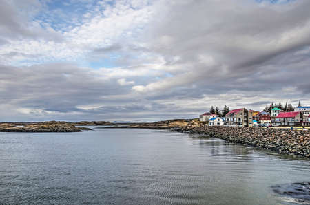 Borgarnes, Iceland, February 28, 2019: colorful houses on the rocky waterfront facing the Atlantic...