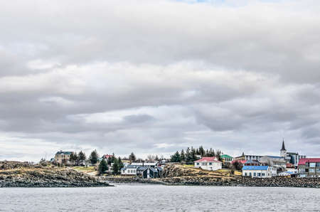 Borgarnes, Iceland, February 28, 2019: colorfull houses, pine trees and a traditional church on the...