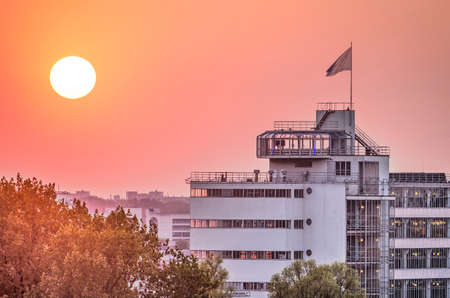 Rotterdam, The Netherlands, April 21, 2019: a fiery sun sets over the upper section of the monumental Van Nelle factory including the iconing tearoom on its roofのeditorial素材