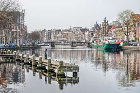 Haarlem, The Netherlands, April 2, 2019: view of the river Spaarne with historic houses, a wooden jetty, a bridge and a historice inland bargeのeditorial素材