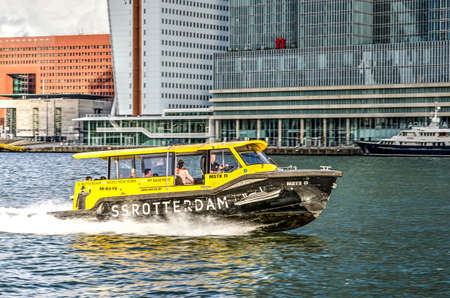 Rotterdam, The Netherlands, August 13, 2018: black and yellow water taxi at full speed on Nieuwe Maas river in front of De Rotterdam buildingのeditorial素材