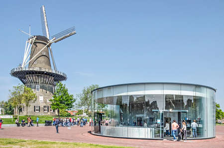 Leiden, The Netherlands, May 18, 2019: Traditional windmill De Valk and the modern circular glass entrance to the parking garage under Lammermarkt square on a sunny day in springtimeのeditorial素材