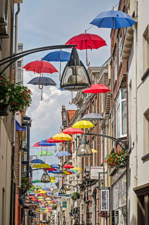 Deventer, The Netherlands, June 18, 2019: colorful umbrellas decorate a narrow shopping street in the old town on a sunny dayのeditorial素材