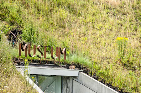 Werkendam, The Netherlands, July 3, 2019: corten steel letters surrounded by grass and wildflowers...