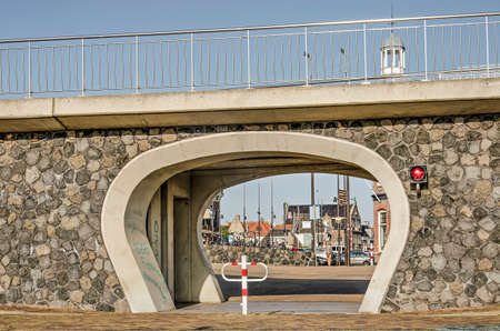 Harlingen, The Netherlands, July 26, 2019: view from the harbour to the old town through a hole in the sea wall, to be closed of by a steel door in case of a stormのeditorial素材