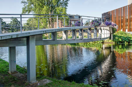 Zwolle, The Netherlands, July 24, 2019: Spinhuis pedestrian bridge with its double arc construction across the ramparts canal with De Spiegel theatre to the rightのeditorial素材