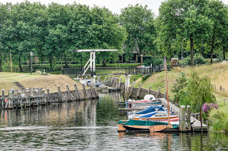 Vollenhove, The Netherlands, August 4, 2019: small yachts and sailing boats and a drwabridge at the tree-lined old harbourのeditorial素材