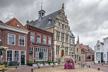 Brouwershaven, The Netherlands, August 10, 2019: the 16th century town hall and some adjacent old houses under a cloudy skyのeditorial素材