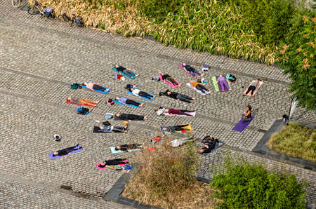 Rotterdam, The Netherlands, September 8, 2018: aerial view of yoga class pracrticing the shavasana pose at the end of the open air lessonのeditorial素材