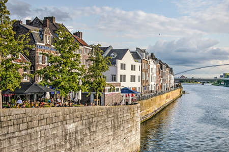 Maastricht, The Netherlands, September 7, 2019: view along the quay at Wyck neighbourhood, with trees, terraces and three or four storey brick housesのeditorial素材
