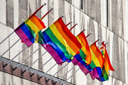Rotterdam, The Netherlands, September 27, 2019: ten rainbow flags waving on the stone facade of...