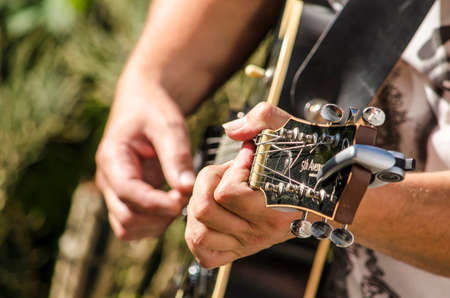 The Hague, The Netherlands, July 8, 2019: Two hands playing a guitar at an open air jam session on a...